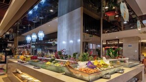 Zona de bufé con diferentes opciones de comida y un mostrador con platos.