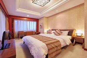 A hotel room with a large bed, bedside tables, a desk, and a television. - Qingdao West Coast City Terrace Detai Hotel (Qingdao)
