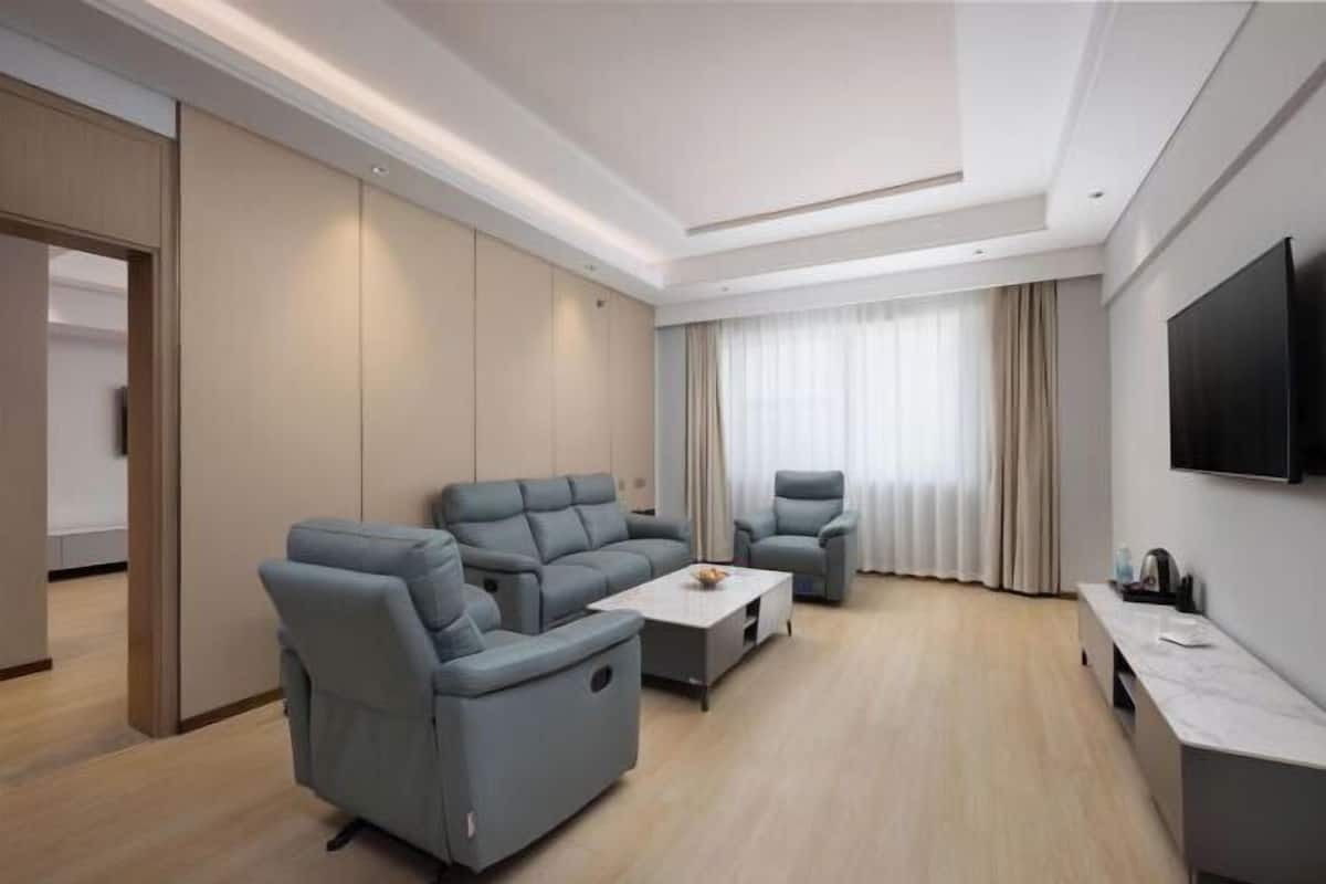 A modern living room with a sofa, armchair, and coffee table.
