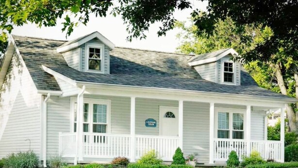 A two-story white house with a front porch, a small attached garage, and a sign indicating it is a bed and breakfast. - Cottage with jacuzzi, Downtown Berlin Ohio (Berlin)