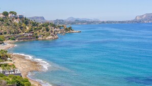 A coastal town with a beach, rocky shoreline, and buildings on a hillside. - Gorgeous home in Trabia (Trabia)