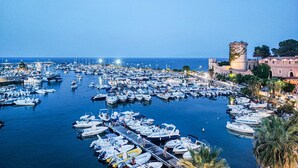 A marina filled with boats, a castle-like structure, and a clear sky. - Gorgeous home in Trabia (Trabia)