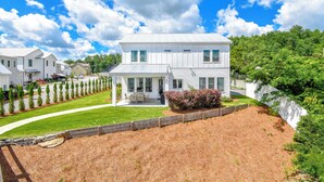 A two-story house with a front porch, a covered patio, and a well-maintained lawn. - Bridge View Retreat, Bridge View Retreat- Luxurious 4Br -Lake Martin Home (Alexander City)