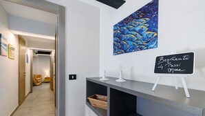 Un pasillo con una recepción, un cuadro de peces colgado en la pared y un letrero en una pizarra.