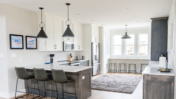 A modern kitchen with a central island, bar stools, and pendant lighting. - Luxury Retreat near Mammoth Cave! (Clarkson)