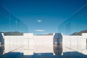 A modern interior with reflective flooring and glass partitions, offering a view of the outdoors. - Langyue Hanfu Travel Theme Inn (Lijiang Ancient City Branch) (Lijiang)