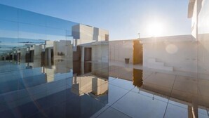 A modern building with reflective glass and concrete structures. - Langyue Hanfu Travel Theme Inn (Lijiang Ancient City Branch) (Lijiang)