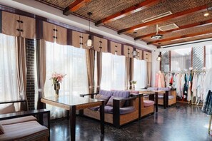 A room with a dining area, seating, and a clothing rack. - Langyue Hanfu Travel Theme Inn (Lijiang Ancient City Branch) (Lijiang)