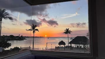 Enjoy a serene view of the ocean from the comfort of this room, featuring a spacious seating area and a large window.
