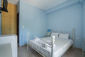 Ein Schlafzimmer mit Bett, Kleiderschrank und einem Bild an der Wand.