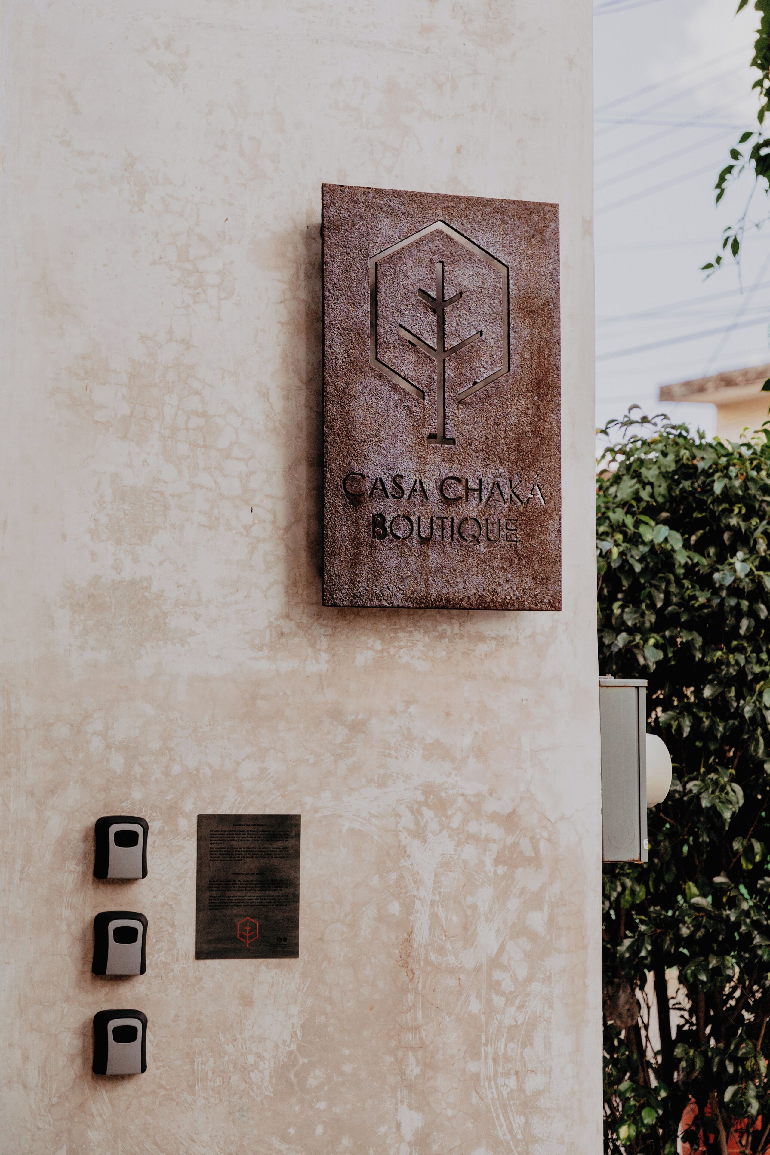 A wall-mounted sign for Casa Chaka Boutique with a hexagonal logo and a vertical line symbol.