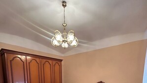 A bedroom with a wooden bed, a large wardrobe, and a chandelier. - Brother's Village (Villardefrades)