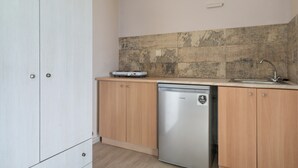 A kitchen with wooden cabinets, a dishwasher, a countertop with a sink, and a tiled backsplash.