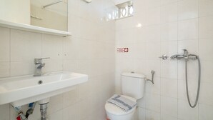 A bathroom with a white sink, toilet, and shower.