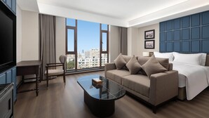 Une chambre d  ’hôtel moderne dotée d’une grande fenêtre, d’un canapé, d’une table basse et d’un téléviseur.