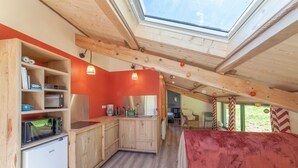 A compact kitchen with wooden cabinets, a microwave, and a refrigerator.