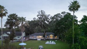 A lakeside property with a dock, outdoor seating, and a well-maintained lawn.