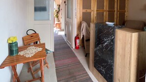 Un pasillo estrecho con paredes y techo de madera, que conduce a una zona de cocina con encimera de mármol.