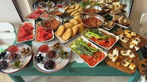 Una mesa con diversos alimentos, incluyendo sandía, aceitunas y queso.