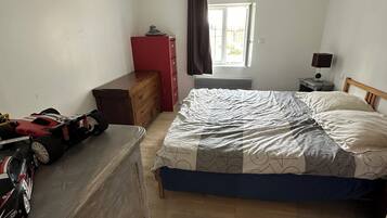 A bedroom with a bed, dresser, and a toy car.