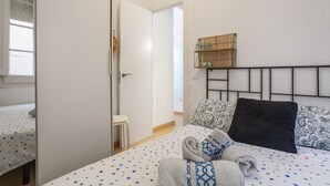 Une chambre à coucher avec un lit, une table de chevet, un miroir et une fenêtre.