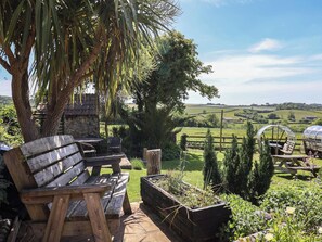 A rustic outdoor seating area with wooden benches and a raised garden bed with plants. - The Spyway Inn (Dorchester)
