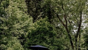 A swimming pool with a pink flamingo float, surrounded by a brick patio and a wooden fence. - 18th Century Cottage w/ heated pool 2 hrs from NYC (Rosendale)