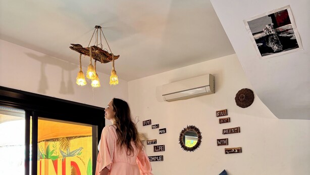A spacious living room with a large window, a sofa, and a decorative wall with motivational phrases. - Charming American Villa – 3BR with AC, WiFi & Pool in Dahab (Dahab)
