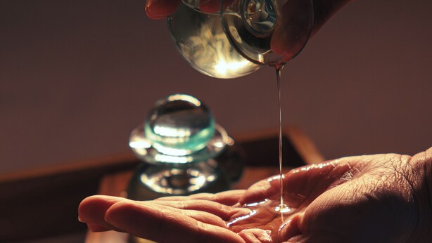 A hand pouring a liquid from a small container into a glass. - Grand Hyatt Cancun Beach Resort – All Inclusive (Cancun)