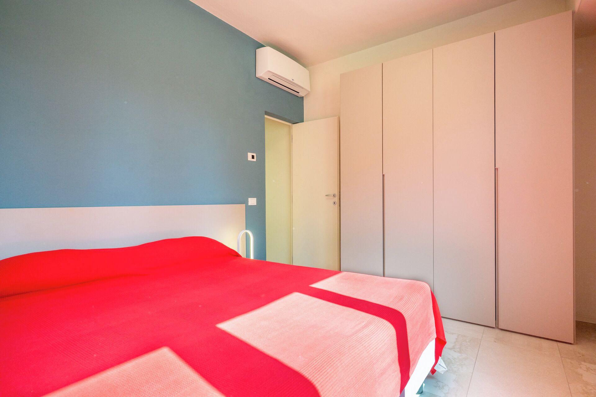 Ein Schlafzimmer mit Bett, Kleiderschrank und Klimaanlage.