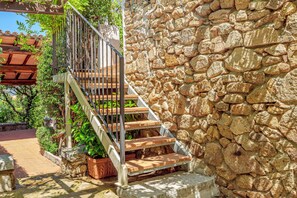 A stone wall, wooden steps, and a metal railing.