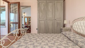 Un dormitorio con cama, armario, mesita de noche y espejo.
