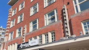 A brick building with multiple windows and a sign reading "Amigo Hotel". - Amigo Hotel (Amsterdam)