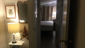 A hotel hallway with a bed, a lamp, a framed picture, and a small table with books. - Cottage Retreat 75 Steps from the shores of spectacular Lake Huron, Sauble Beach (Sauble Beach)