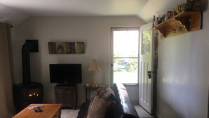 A living room with a fireplace, a television, a sofa, and a coffee table. - Cottage Retreat 75 Steps from the shores of spectacular Lake Huron, Sauble Beach (Sauble Beach)