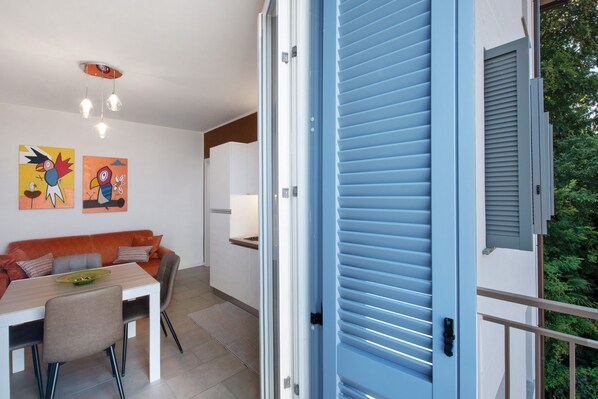A modern interior with a dining area, a sofa, and a blue door. - Apartment 'Diamond House Holiday' with Mountain View, Wi-Fi and Air Conditioning (Capiago Intimiano)