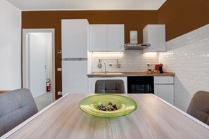 A modern kitchen with white cabinets, a wooden countertop, and a green glass bowl on the table. - Apartment 'Diamond House Holiday' with Mountain View, Wi-Fi and Air Conditioning (Capiago Intimiano)