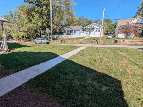 Una calle residencial con casas, aceras y un coche estacionado.