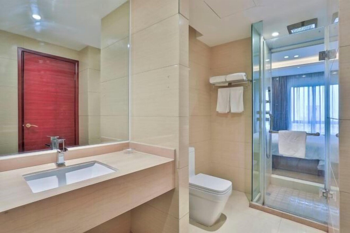 Ein modernes Badezimmer mit Waschbecken, Spiegel, Toilette und Duschkabine.