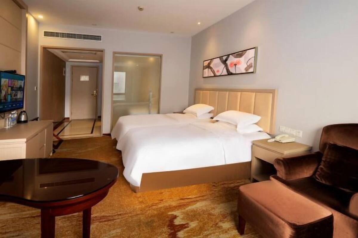 Een hotelkamer met een bed, een bureau, een stoel en een televisie.