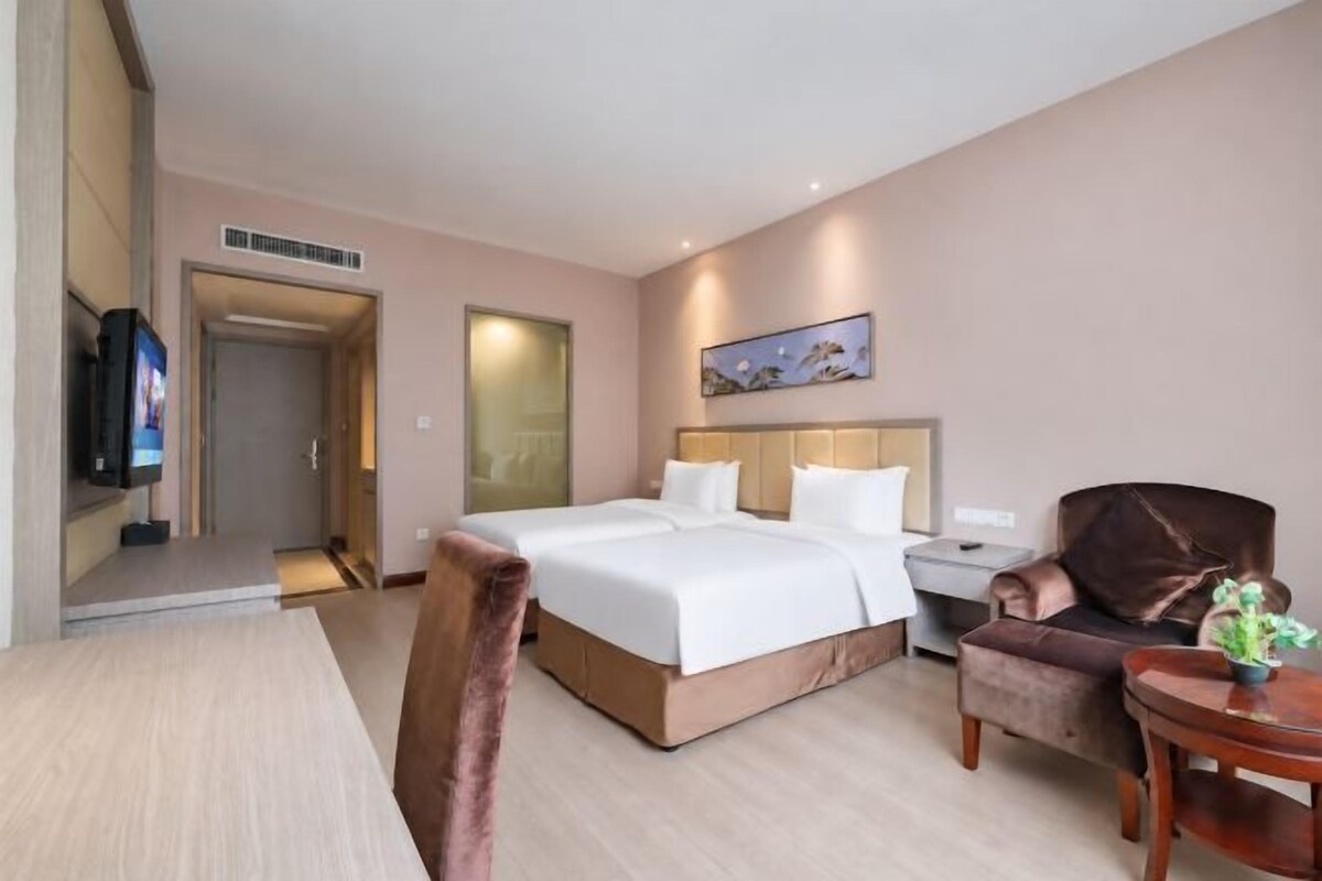 Una habitación de hotel con cama, escritorio, silla y televisión.