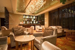 A lobby with sofas, a round table, a bar area, and a large window. - Hangzhou Tong Huan Hotel (Hangzhou)