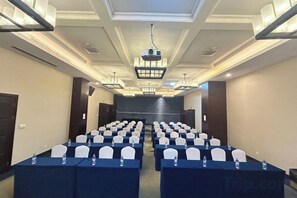 A conference room with rows of tables, chairs, and a projector screen. - Hangzhou Sanli Jingchen Hotel (Hangzhou)
