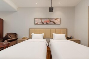 A hotel room with two beds, a headboard, a nightstand, a chair, and a table. - Hangzhou Tong Huan Hotel (Hangzhou)