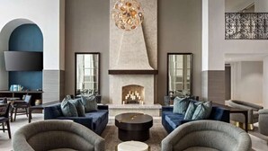 A modern living room with a fireplace, sofas, and a large chandelier.