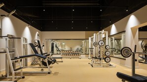 A gym with various exercise equipment, including weight machines and free weights, arranged in a spacious layout. - Appartment im Ferienpark in Schoneck (Schoeneck)
