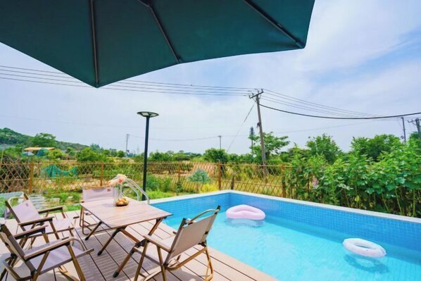 Relax by the pool surrounded by lush greenery and enjoy a refreshing swim.