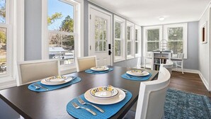 A dining area with a long table, chairs, and a view of the outdoors. - New! Lakeview at Branch Lake (Ellsworth)