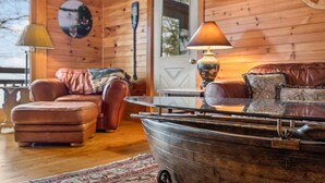 A cozy cabin interior with a wooden interior, a boat in the foreground, and a door with a window. - Moose Lodge on the Lake (Ellsworth)