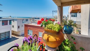 A balcony with potted plants and a view of the sea. - Steps to Ocean: Manhattan Beach Gem w/ Deck! (Manhattan Beach)